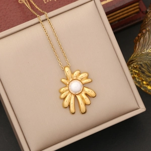Detail of a gold flower pearl necklace displayed in a beige leather jewelry gift box