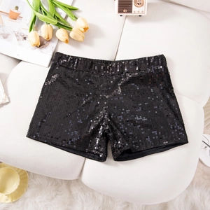 Nahaufnahme der schwarzen Pailletten-Shorts mit hoher Taille auf einem weichen Sofa