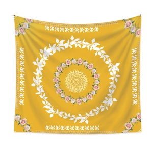 Detail of bohemian mandala tapestry with yellow backdrop and rose floral patterns
