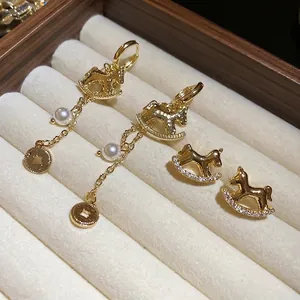 Set de boucles d'oreilles cheval à bascule avec perles et pièces sur coffret en velours
