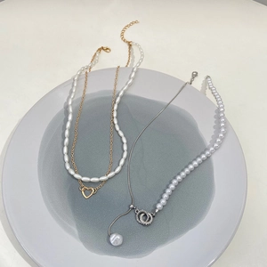 Elegant layered pearl necklace with heart pendant and asymmetric gold chain jewelry
