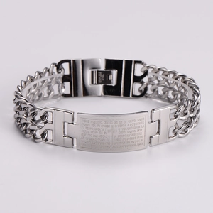 Detailed macro view of silver stainless steel curb chain with engraved Spanish prayer plaque