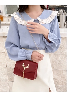 Rote Kette Umhängetasche mit goldenem Hirschkopf-Dekor an einem Model-Outfit