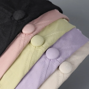 Detailed close-up of quilted cotton baseball caps with reinforced stitching and top button