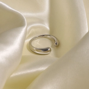 Polished silver stainless steel open ring displayed on premium champagne silk fabric
