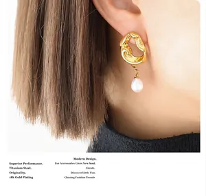 Macro view of 18K gold plated irregular lava earrings with white freshwater pearl drops
