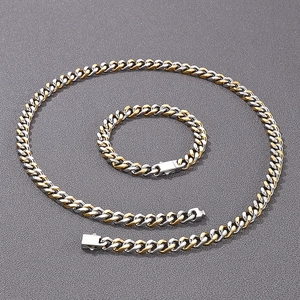 Détail d'un ensemble collier et bracelet maille gourmette bicolore or et argent avec fermoir boîte
