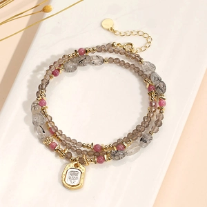 Multi-layer beaded crystal bracelet with pink stones and a golden portrait pendant