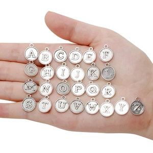 Detailed view of twenty-six silver alloy alphabet charms for DIY jewelry crafting