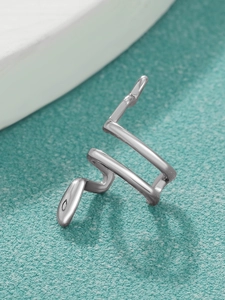 Primo piano dettagliato di un ear cuff a serpente in argento con finitura a specchio lucida