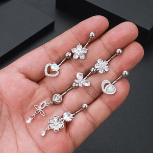 Macro detail of various zircon belly rings held by hand to show size and sparkle