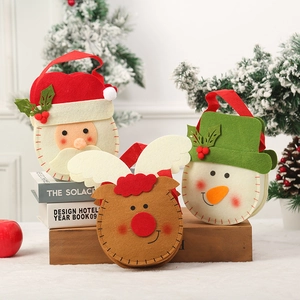 Détail de sacs cadeaux de Noël artisanaux en feutre avec motifs de Père Noël et de renne