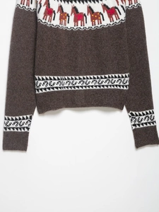 Close-up of jacquard knit pattern featuring horse motifs and ethnic geometric texture