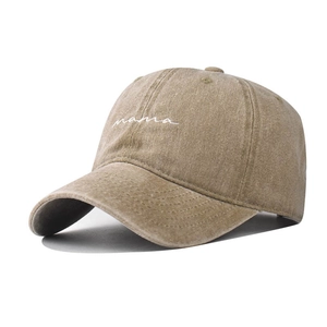 Detailed view of the embroidered white mama script on a washed khaki cotton baseball cap