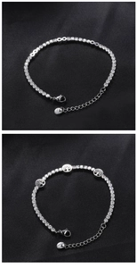 Detail of silver steel tennis bracelets with infinity and tree of life charms on black silk