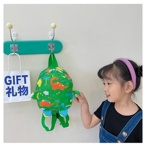 Kids green dinosaur backpack with colorful cartoon prints and adjustable straps worn by child