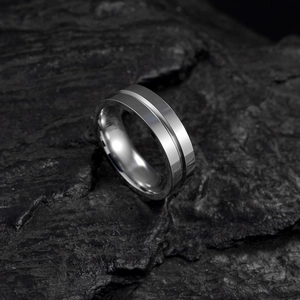 Minimalist 6mm stainless steel ring with center groove on dark volcanic rock background