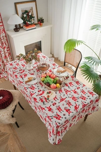 Close-up of Santa Claus pattern on red linen tablecloth with festive dinner table decor