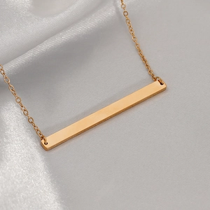 Minimalist gold bar pendant necklace in titanium steel on white silk background