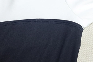 Détail des coutures contrastées bleues et blanches sur tissu à maille fine avec finition