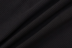 Close-up of black ribbed knit fabric texture showing high-quality elastic threads