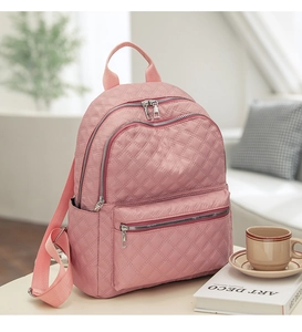 Detalle de mochila rosa acolchada con cremalleras múltiples y textura ligera y suave