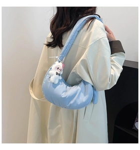 Détail du sac hobo matelassé bleu clair avec une décoration de lapin en peluche