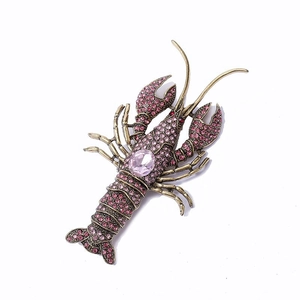 Vintage lobster brooch in gold alloy with pink rhinestones and a large oval center gem