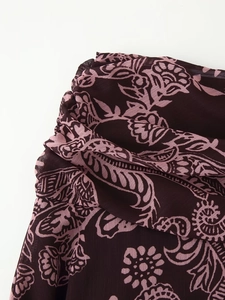 Détail macro du tissu à imprimé floral violet foncé avec plis doux sur une jupe