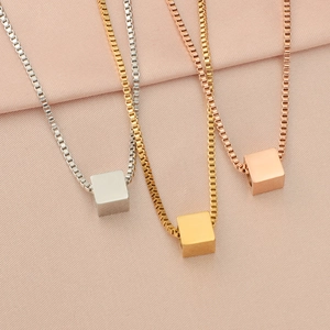 Detailed shot of cube pendant necklaces in silver, gold, and rose gold titanium steel