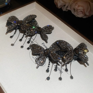 Detail of butterfly hair clips with sparkling rhinestones and long tassel chains