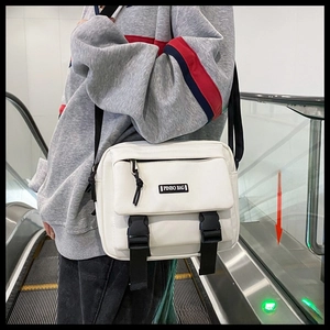 Detailed view of a white canvas crossbody bag with PINBO BAG logo and double buckle closure