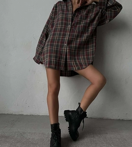 Detail shot of the red and grey plaid oversized shirt paired with black platform boots
