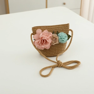 Detail view of straw woven crossbody bag with pink, mint, and tan 3D fabric flowers