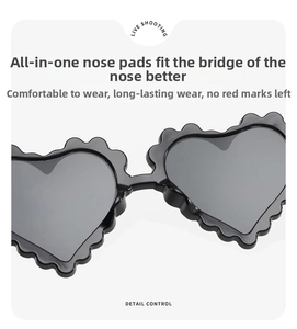 Detail of integrated nose pads and wavy heart-shaped frame of kids black sunglasses