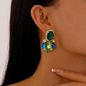 Macro shot of vintage style earrings with green gemstones and cascading crystal fringe