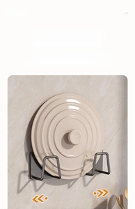 Adjustable wall-mounted gunmetal pot lid rack showing spacing flexibility on marble wall