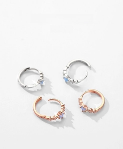 Macro shot of S925 sterling silver hoop earrings with blue zircon stones in silver and gold