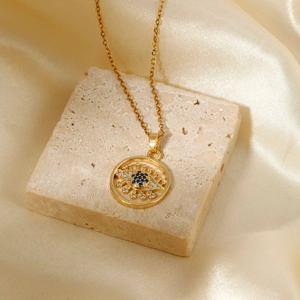 Fashionable gold evil eye pendant necklace with blue and white crystals on silk fabric