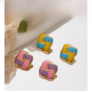 Macro detail of square stainless steel stud earrings with colorful enamel weave pattern