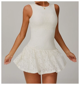 Close-up of intricate floral lace texture and pleated hem on this white mini dress