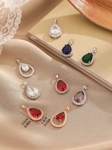 Detailed view of colorful teardrop zircon pendants with size dimensions on vintage background