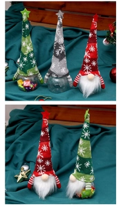 Nahaufnahme von drei festlichen Weihnachtswichtel-Bonbongläsern mit bunten Strickmützen