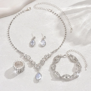 Detailed flat lay of silver bridal jewelry set with sparkling teardrop crystal pendants