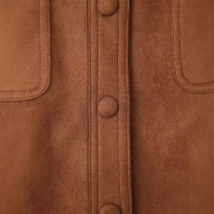 Chaqueta motera vintage de ante marrón con bolsillos delanteros y detalles de botones de cerca