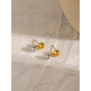 Gros plan détaillé des boucles d'oreilles boules bicolores en or 18 carats et argent