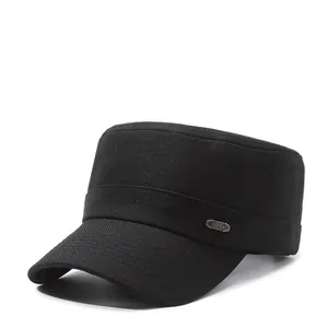 Detail of a black flat top military cap featuring a vintage metal Fashion emblem on the side