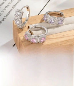 Macro shot of silver copper hoop earrings with white, purple and pink cubic zirconia