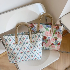 Chic pink and blue floral canvas tote bags with leather handles on designer chairs