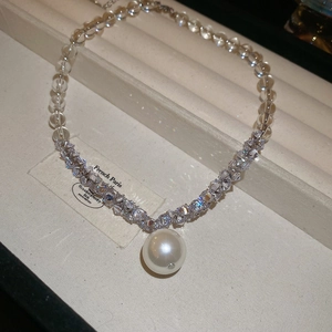 Macro detail of a pearl pendant necklace with sparkling beads in a French jewelry box
